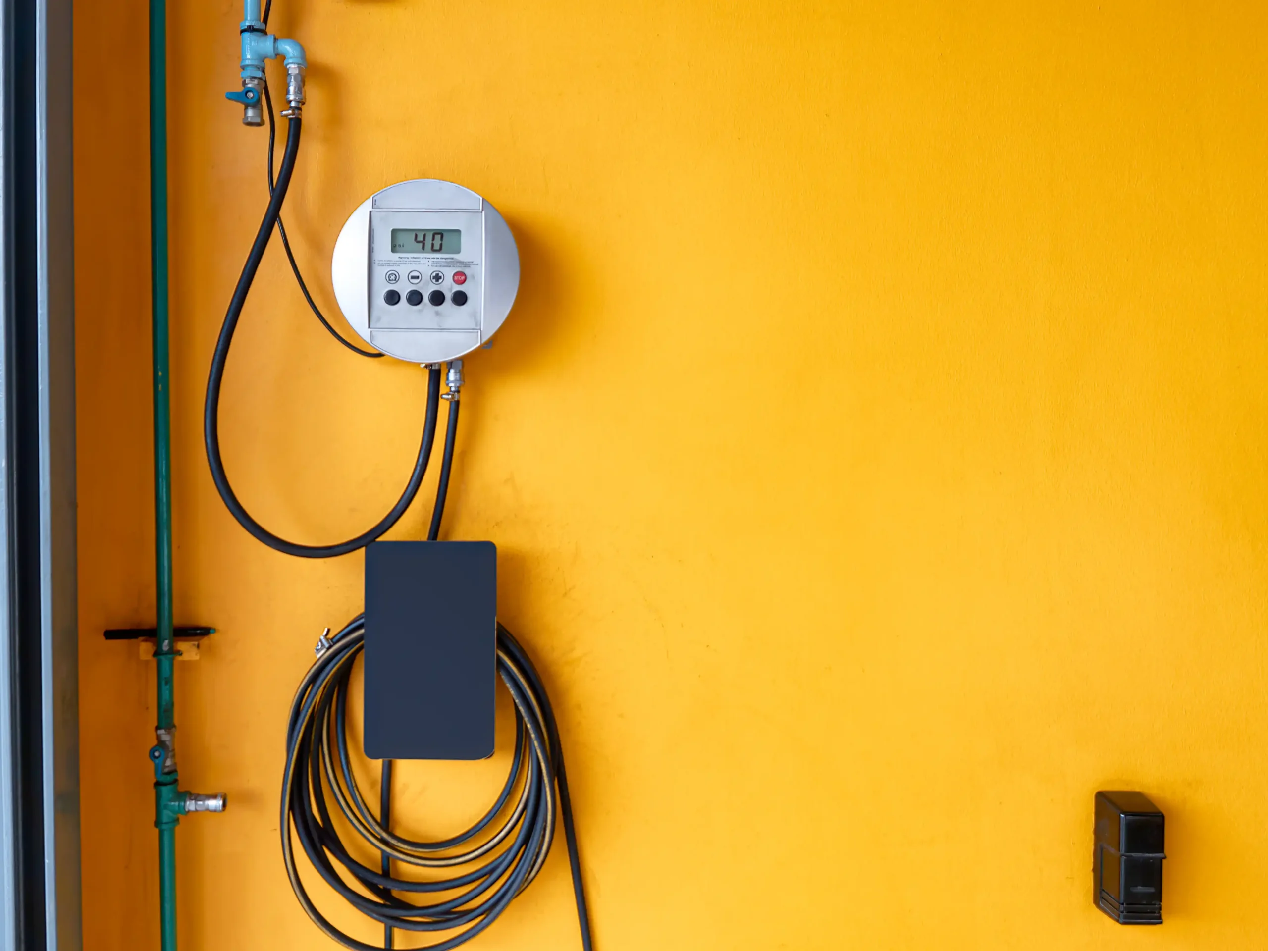 pressure-gauge-and-hose-on-yellow-wall-2026-03-24-22-15-52-utc
